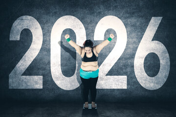 Overweight woman cheering on a scale with 2026 text behind her.