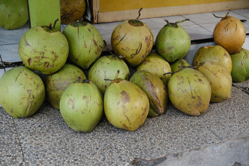 Fresh Young Green Coconuts on the Floor of a Local Warung