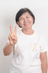 Elderly woman with Peach Ribbon for September Uterine Cancer Awareness month, Endometrial Cancer, Gynecologic, Uterus and Ovaries, Endometriosis, June Vaginal cancer and World cancer day concept