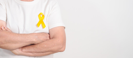 Elderly with Yellow Ribbon for concept of yellow September, Suicide prevention day, Childhood, Pediatric, bone and bladder cancer Awareness month, support survivor. Healthcare and World Cancer day