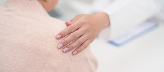 doctor holding hands with elderly female patient, showing empathy and support during a medical...