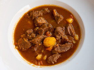 Appetizing braised beef meat with potatoes and vegetable in sauce. Classic comfort food concept