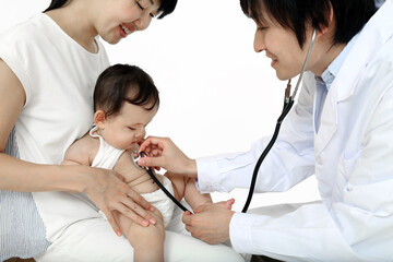 お母さんに抱かれ、聴診器で診察される赤ちゃん