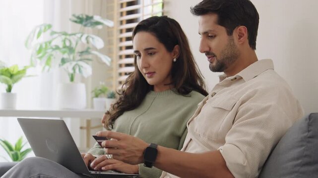 Couple using tablet and credit card to shop online through e-commerce app, making payment and browsing modern platform with promo codes and discount offers