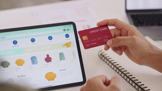 Couple using tablet and credit card to shop online through e-commerce app, making payment and browsing modern platform with promo codes and discount offers