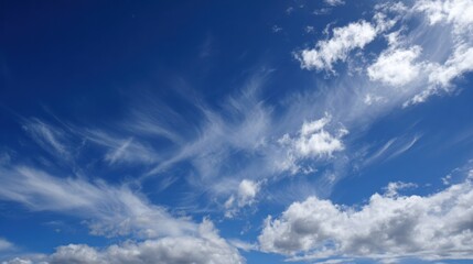 Obraz premium A bright blue sky features wispy white clouds floating above, indicating a calm and pleasant day. Sunlight bathes the atmosphere, creating a serene ambiance.