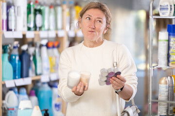 Female shopper chooses scented candles in supermarket for a romantic evening
