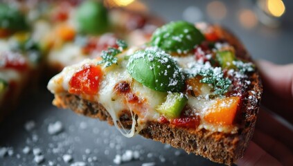 Hand holds slice of whole wheat pizza topped with mozzarella, peppers, and herbs