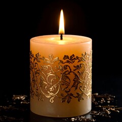 A tan pillar candle with gold leaf detailing burns brightly against a black background, scattered gold flecks at its base