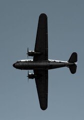 Military Aircraft Flying in Clear Sky with Dark Silhouette