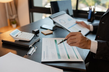 a businessman is reviewing accounting and financial statistics documents in his private office, the statistician prepares various charts and documents for a meeting