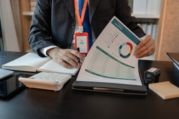 an accounting and financial officer is working on documents in the office, a businessman is reviewing his company's historical budget statistics, finance, marketing