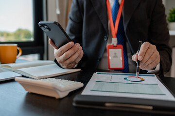 a businessman woks with a foreign company and uses a smartphone to help send and receive information, marketing manager sends statistic information to accounting department via a smartphone
