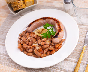 Top view of Catalan stewed beans with sausage served on plate. Butifarra con alubias