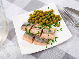 Appetizing herring, cut into pieces, with canned green peas