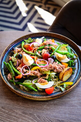 Stylized close-up photograph of a beautifully plated salad served in a restaurant. 