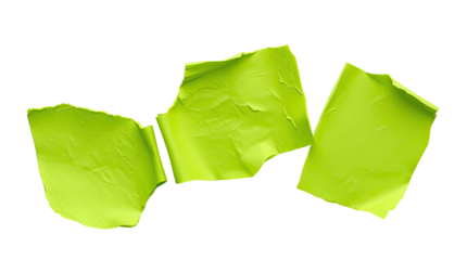 Three pieces of crumpled green paper are scattered on a white surface demonstrating a disorganized workspace often seen in creative settings