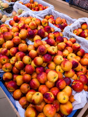 Fresh peaches and nectarines displayed at a local market stand during the summer harvest season in a bustling town