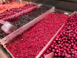 Assorted berries displayed in containers at a vibrant market during daytime