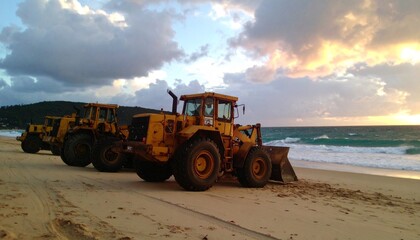 Obraz premium Sunset Beach Scene with Front-End Loaders Industrial Stillness Amid Natural Beauty