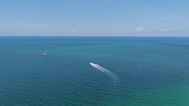 Parasailing sport activity. Parachute in the sky. Extreme rest and parasailing. Summer vacation. Sea sport. Parachute parasail. Water sport on summer vacation. Parasailing recreation with parachute