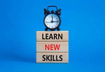 Learn new skills symbol. Concept words Learn new skills on wooden blocks. Beautiful blue background...
