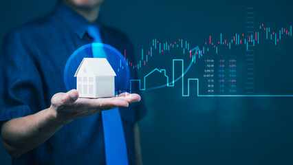 Businessman holding house model with rising stock chart for real estate investment growth and...