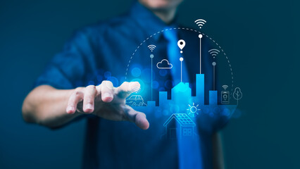Businessman pointing at smart city hologram with IoT and wireless icons for digital infrastructure...