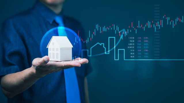 Businessman holding house model with rising stock chart for real estate investment growth and financial housing performance