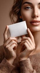 A refined and confident woman with elegant features and captivating eyes holds a blank business card suggesting a professional sophisticated and inviting persona