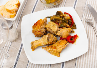 Appetizing chicken drumstick served with stewed vegetables on plate