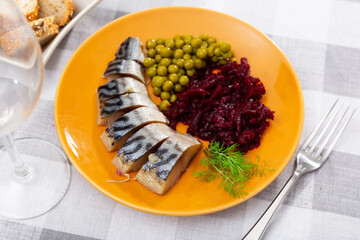 Service plate containing cold bonito with grated beetroot and green peas with necessary table laying