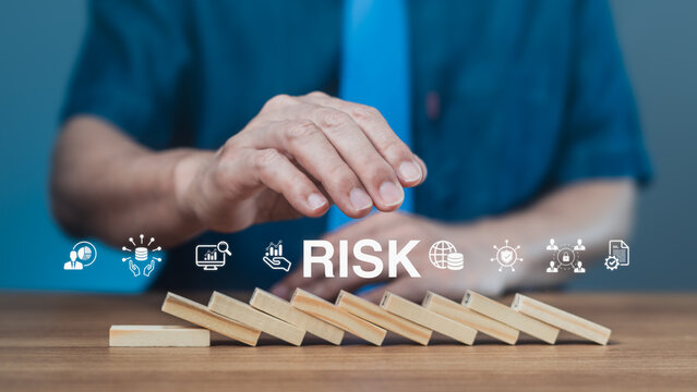 Cybersecurity and data risk management concept with businessman's hand stopping dominoes and digital safety icons