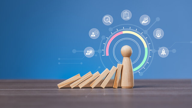 Leadership and risk management concept with wooden figure stopping dominoes and business strategy icons on blue background, representing resilience and decision-making in crisis