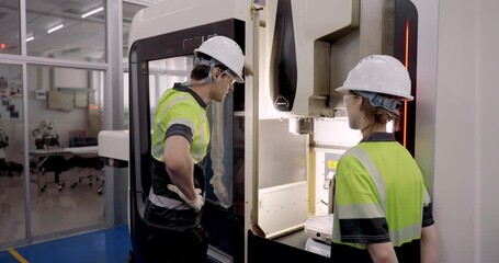 technicians opening cnc machine panel during slowmotion automation training focusing on internal components inspection and safe handling procedures in industrial education setting