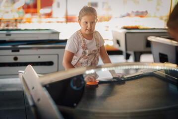 Girl playing air hockey in an arcade center