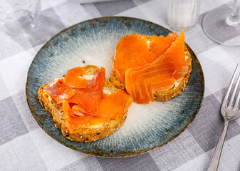 Two sandwiches with white bread butter and smoked salmon