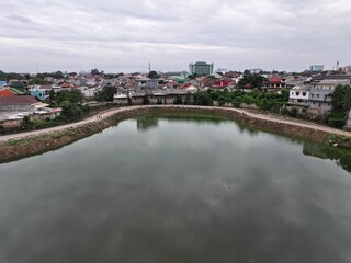 Fototapeta premium A beautiful lake with ornamental plants growing on the edge is located in the middle of the city.