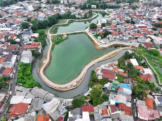 A beautiful lake with ornamental plants growing on the edge is located in the middle of the city.