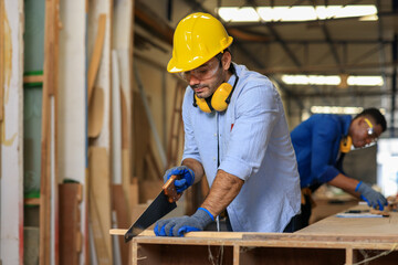 young male carpenter worker hold wooden plank at the carpentry workshop
