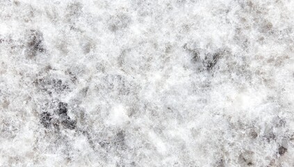 Close-up of a light-grey stone surface with small, dark grey flecks and a slightly rough texture