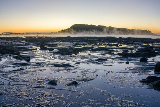 Sunrise over rock platform at Broulee Beach, New South Wales, Australia