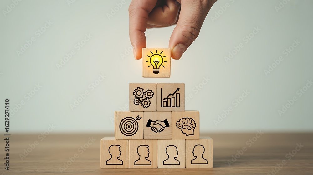 Poster hand placing illuminated lightbulb block atop stacked business concept cubes image