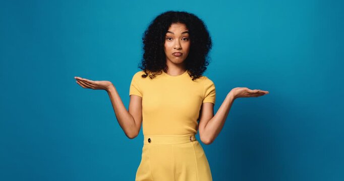 Face, confused and woman in studio, shrug and body language with questions on blue background. Portrait, space or person with facial expression, reaction or whatever with hand gesture, doubt or emoji