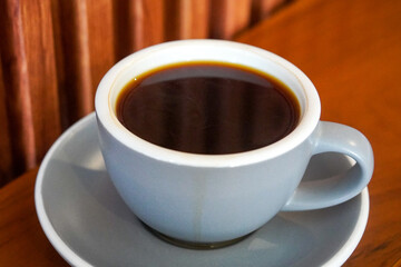 Hot Americano, Indonesia, captured on August 6, 2025. A bold black coffee served in a clean ceramic cup, rich aroma rising with steam, perfect for a minimalist café scene or a calm morning at work