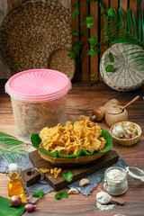 Indonesian shrimp and peanut rempeyek, a traditional chip food with a brown wooden background