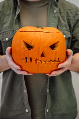 Closeup of spooky halloween lantern in man's hand. Festive vertical banner