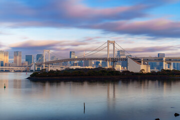 Obraz premium Skyline of Tokyo Rainbow Bridge in morning sunlight under blue sky with cloud