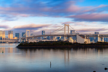 Skyline of Tokyo Rainbow Bridge in morning sunlight under blue sky with cloud
