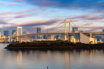 Skyline of Tokyo Rainbow Bridge in morning sunlight under blue sky with cloud
